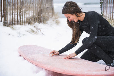 Woman going surfing during winter snow