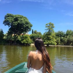 Rear view of woman in water against trees