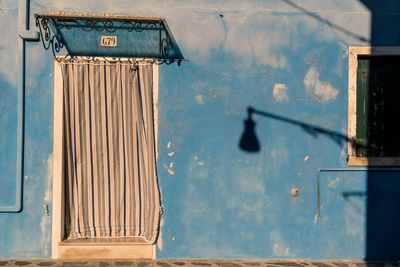 Covered door of old building with shadow of street lamp