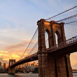 Low angle view of brooklyn bridge against cloudy sky