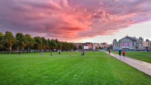 Group of people on soccer field against sky