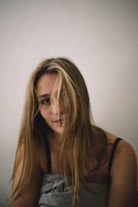 Beautiful young woman against wall at home