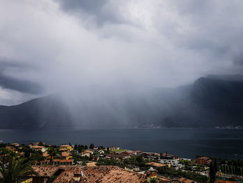 Aerial view of townscape by sea against sky