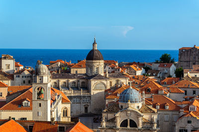 View of buildings and sea against blue sky