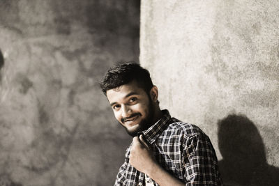 Portrait of man standing by wall