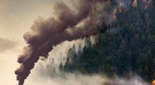 Smoke emitting from chimney against sky