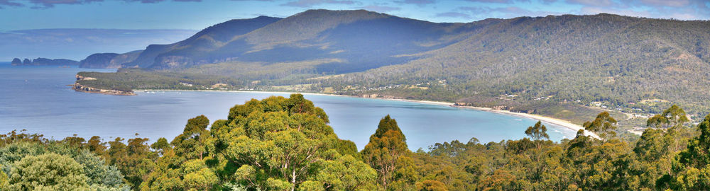 Scenic view of lake by mountains against sky