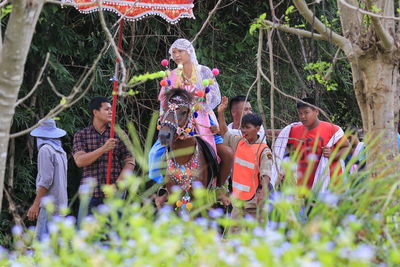 People standing by flowering plants