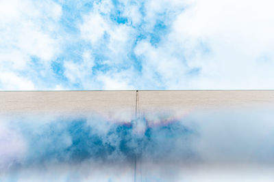 Smoke stack against cloudy sky