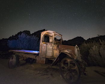 Abandoned car against sky at night