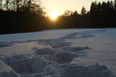 Close-up of snow covered landscape during sunset