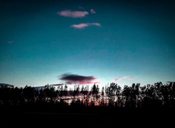 Silhouette trees against sky at dusk