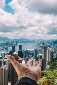 Midsection of man and cityscape against sky