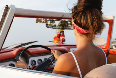 Rear view of woman sitting in car