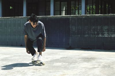 Full length of young man sitting outdoors