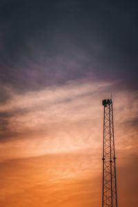 Low angle view of silhouette electricity pylon against sky during sunset