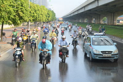 Group of people riding bicycle on road in rain