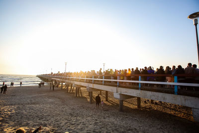 People on beach against clear sky