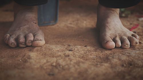 Low section of person on dirt floor