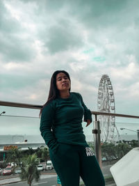 Young woman looking at camera against sky