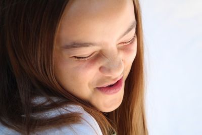 Close-up of girl making face against white background