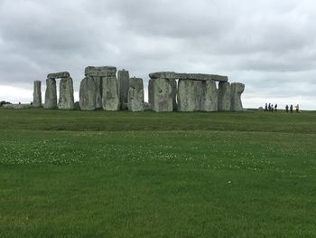 Built structure on field against cloudy sky