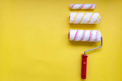 Close-up of ice cream cone against yellow wall