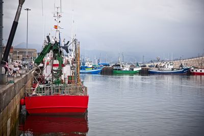 Boat moored at harbor against sky