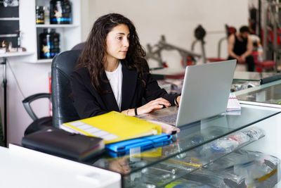 Young businesswoman using laptop at office