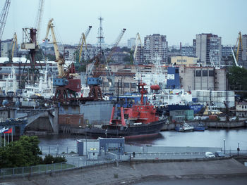 Sailboats in city at harbor against sky