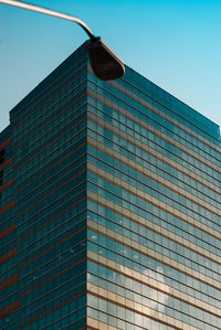 Low angle view of modern building against clear blue sky