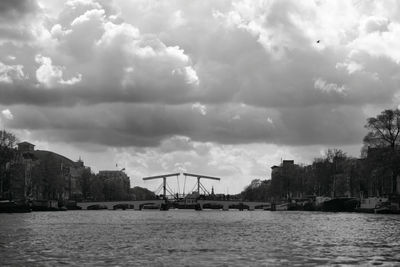 Scenic view of river by city against sky