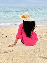 Rear view of woman with umbrella on beach