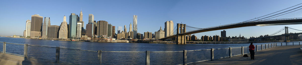 City at waterfront against blue sky