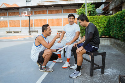 Young man sitting on seat in park