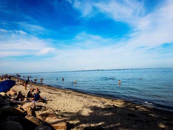 People on beach against sky