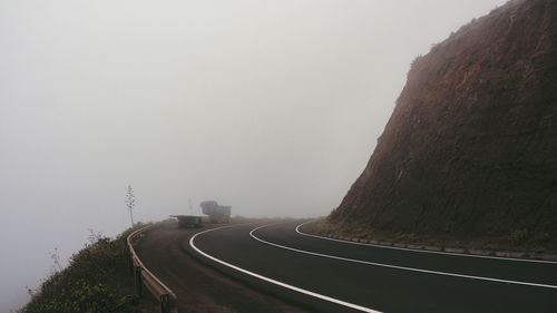 Road amidst trees against sky