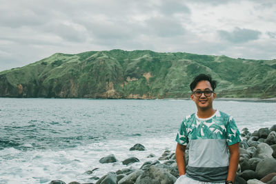 Portrait of man in sea against mountains