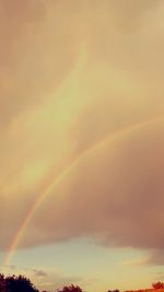 Low angle view of rainbow against sky during sunset