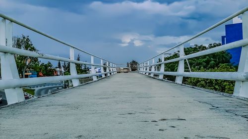 Empty footbridge against sky