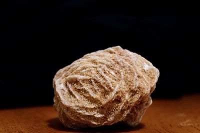 Close-up of bread on table against black background