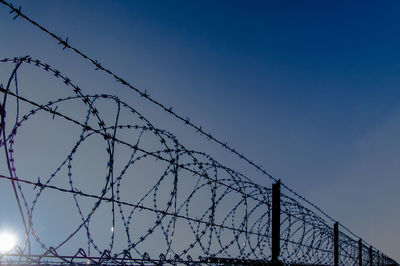 Low angle view of barbed wire against sky