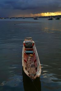 Boats in sea at sunset