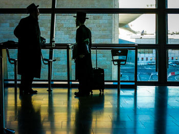 Rear view of people standing at airport