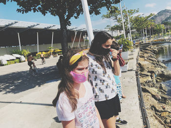 Friends wearing mask standing at promenade