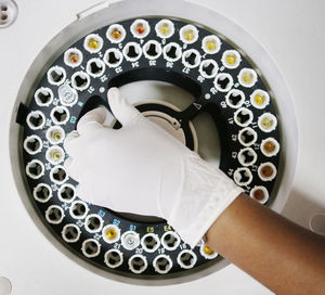 Overhead view of scientist using centrifuge machine in laboratory