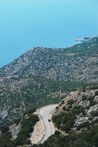 High angle view of road amidst trees against clear sky