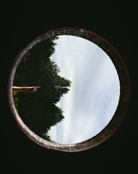 Trees and sky seen through circular shape window