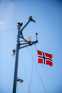 Flag of norway attached to ship's mast, ruffled by wind, flutters beautifully in the breeze.