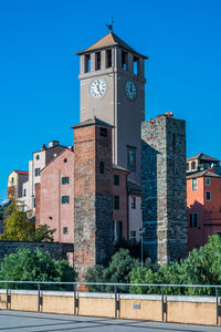 Low angle view of clock tower against buildings in city